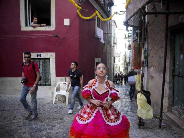 A reveler from the typical Lisbon neighborhood, Alfama, walks in costuem on her way to the Saint Anthony's Parade on Avenida da Liberdade, in Lisbon. Lisbon celebrates Saint Antony's day, its protector, with a parade that gathers participants from several typical neighborhoods of the city. AFP Photo/Patricia De Melo Moreira