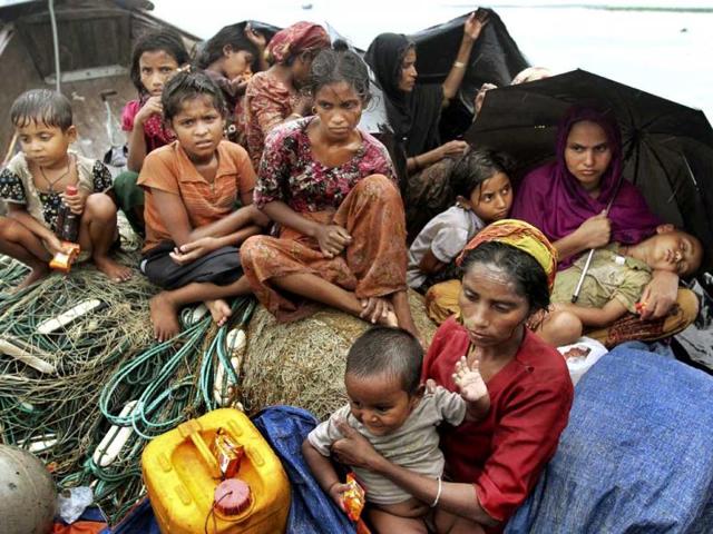 Rohingya Muslims who fled Myanmar to Bangladesh to escape religious violence, sit in a boat after being intercepted crossing the Naf River by Bangladesh border authorities in Taknaf, Bangladesh. AP Photo/Anurup Titu