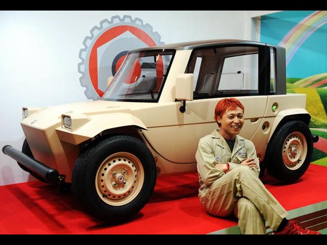 Japan's car designer Kota Nezu displays Japanese auto giant Toyota Motor's concept model of a three-seater electric vehicle with toy-like design body "Camatte-Daichi". The small sized electric vehicle, in length of 2.7m and width of 1.3m, can changed its style with different body panels. AFP/Yoshikazu Tsuno