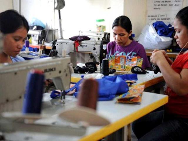 A female worker sews recycled materials into handbags at the Philippine Christian Foundation (PCF) building in Manila. In the midst of the Philippines' most notorious slum, British expat Jane Walker transforms lives by turning rubbish into top-end fashion items. (AFP Photo)