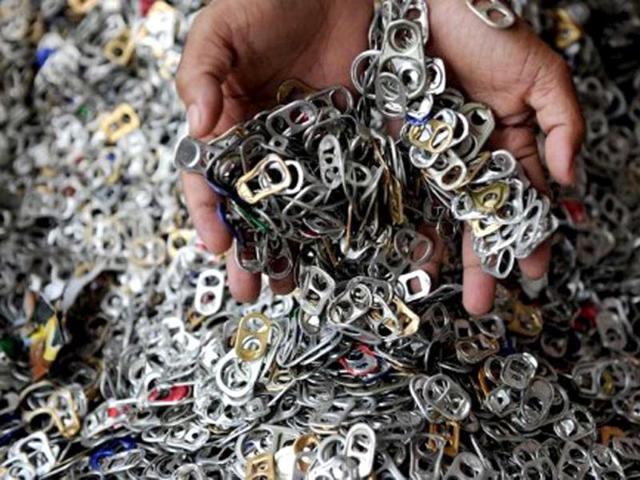 A worker shows push-tabs from aluminum beverage cans that will be used in making top-end fashions items at the Philippine Christian Foundation (PCF) building in Manila. A unique four-story building houses the Philippine Christian Foundation, an organisation Walker founded 16 years ago to help scavengers at the Smokey Mountain garbage dump in Manila's chaotic bayside Tondo district. (AFP Photo)