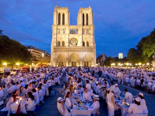 People attend the White Dinner event in front of the Notre Dame Cathedral in Paris. Participants who attend the dinner, which takes place at a different place in Paris every year, are required to be dressed in white and bring their own food, drink and cutlery to the event. Reuters/UNI