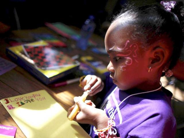 Sunshine, 7, makes a Father's Day card for her father Kinney, who said he was serving life for murder, during a visit to San Quentin state prison in San Quentin, California. An annual Fathers' Day event, "Get On The Bus" brings children in California to visit their fathers in prison. Reuters/Lucy Nicholson