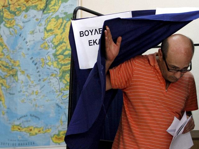 A Greek man leaves the booth after voting during the elections in Athens. AP Photo/Petros Karadjias