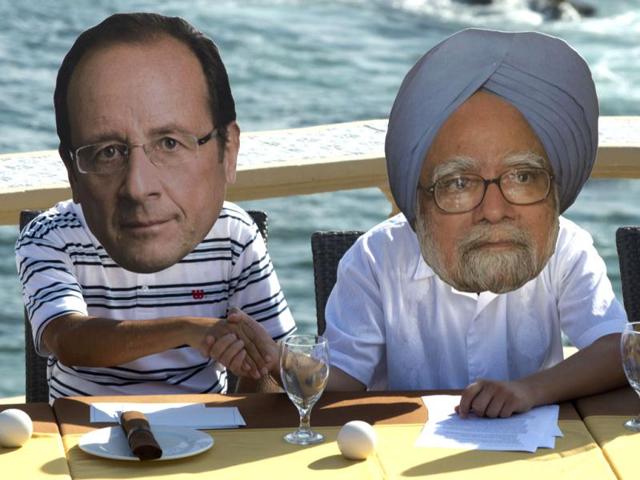 Members of the international organization OXFAM wearing masks depicting French President Francois Hollande(L) and Indian Prime Minister Manmohan Singh are seen during a protest in Cabo San Lucas, Baja California, Mexico on the eve of the G20 Summit opening. AFP Photo / Yuri Cortez