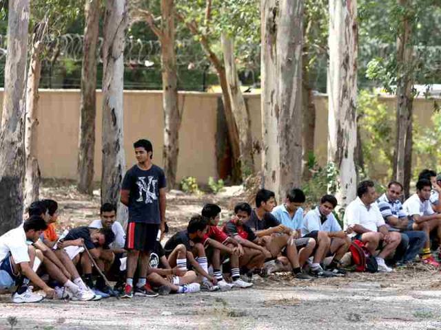 Aspirant students rest under tree shades during the Fitness trail test for admission at Shri Ram College of Commerce in New Delhi. HT/M Zhazo