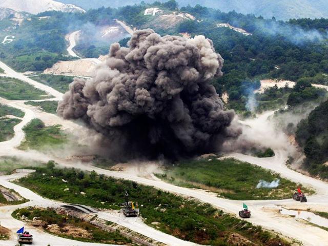 Smokes are seen as heavy armored vehicles wait during a South Korea-US joint military live-fire drills at Seungjin Fire Training Field in Pocheon, South Korea, near the border with North Korea. The drills were held in a show of combat readiness ahead of the 62nd anniversary of the start of the Korean War on June 25. (AP Photo/Lee Jin-man)