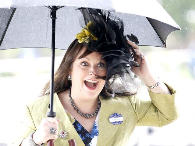 A race goer struggles to keep her hat on in strong winds on the fourth day at Royal Ascot, southwest of London. (Reuters/Andrew Winning)