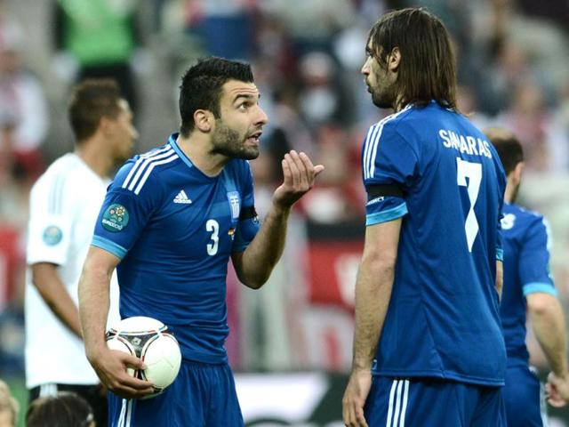 Greek defender Giorgos Tzavellas (L) chats with Greek forward Giorgios Samaras during the Euro 2012 football championships quarter-final match Germany vs Greece at the Gdansk Arena. (AFP photo/Aris MEessinis)
