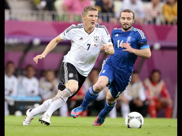 Germany's Bastian Schweinsteiger, left, and Greece's Dimitris Salpigidis go for the ball during the Euro 2012 soccer championship quarterfinal match between Germany and Greece in Gdansk. (AP Photo/Ivan Sekretarev)