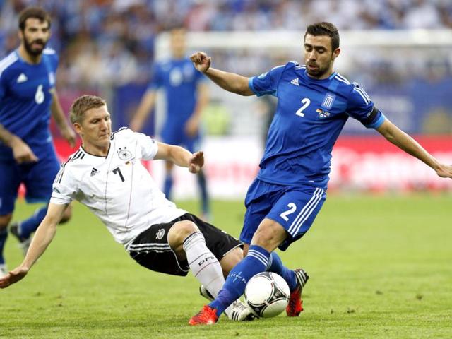 Germany's Bastian Schweinsteiger tackles Greece's Yiannis Maniatis during the Euro 2012 soccer championship quarterfinal match between Germany and Greece in Gdansk, Poland. (AP Photo/Jon Super)