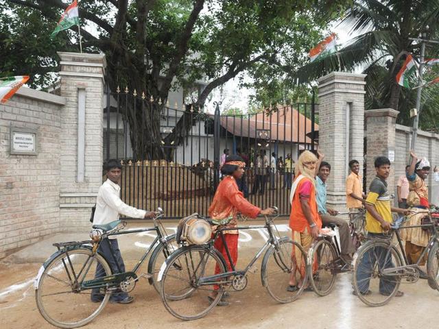 Villagers with their cycles pass the ancestral house of the finance minister and the ruling UPA candidate for the Presidential election Pranab Mukherjee before his arrival in Mirati village. (AFP photo/Dibyangshu Sarkar)