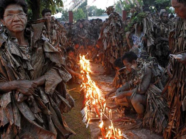 Devotees, covered with mud and dried banana leaves, light candles as they take part in a religious ceremony celebrating the feast day of their Catholic patron Saint John the Baptist in the village of Bibiclat, Nueva Ecija, north of Manila, June 24, 2012. Hundreds of devotees took part in this annual religious tradition, which has been held in the village since 1945. Reuters/Erik De Castro