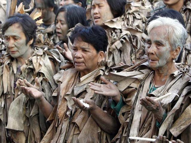 Devotees, covered with mud and dried banana leaves, pray during a holy mass celebrating the feast day of their patron Saint John the Baptist in the village of Bibiclat, Nueva Ecija, north of Manila, June 24, 2012. Hundreds of devotees took part in this annual religious tradition, which has been held in the village since 1945. Reuters/Erik De Castro
