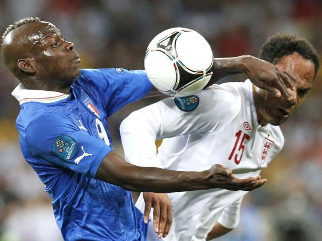Italy's Mario Balotelli, left, and England's Joleon Lescott challenge for the ball during the Euro 2012 soccer championship quarterfinal match between England and Italy in Kiev, Ukraine. (AP Photo/Michael Sohn)