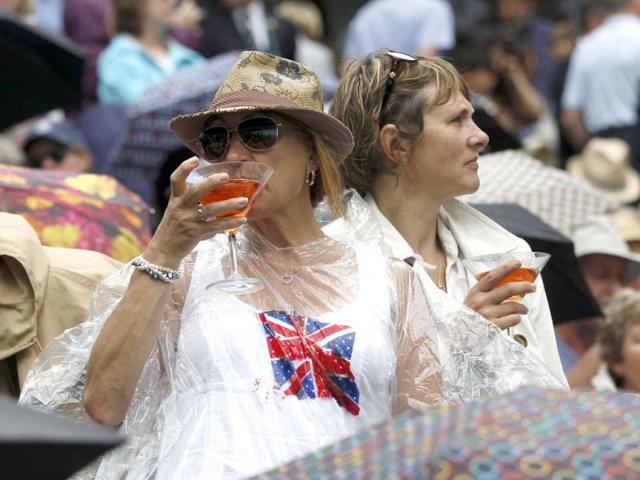 Fans try to keep dry on Centre Court during a spell of rain at the Wimbledon tennis championships in London. (Reuters) Fans try to keep dry on Centre Court during a spell of rain at the Wimbledon tennis championships in London. (Reuters)