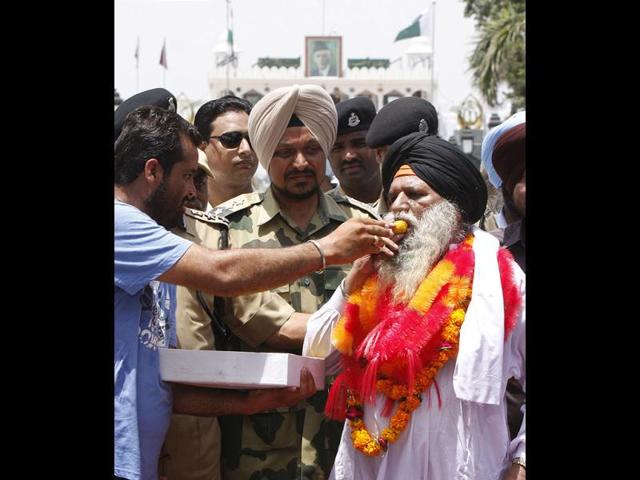 Surjeet Singh is offered sweets by one of his relatives after crossing over to India at Amritsar. (Munish Byala/HT Photo)