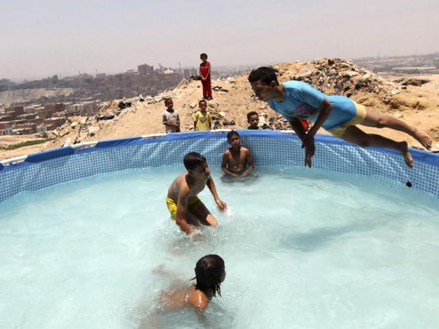 Boys play in a portable swimming pool.