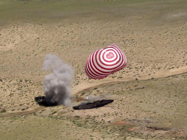 This photo shows the re-entry capsule of China's Shenzhou-9 spacecraft lands safely in Siziwang Banner of north China's Inner Mongolia Autonomous Region. AP Photo/Xinhua, Wang Jianmin