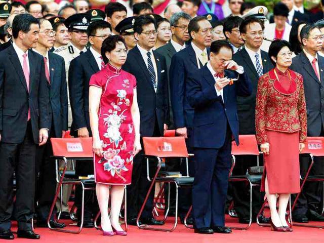 New Hong Kong Chief Executive Leung Chun-ying (L) looks over at outgoing chief executive Donald Tsang (2nd R) as he wipes his eyes during a flag-raising ceremony to celebrate the 15th anniversary of the establishment of the Hong Kong Special Administrative Region (HKSAR). (AFP Photo/Richard A. Brooks)