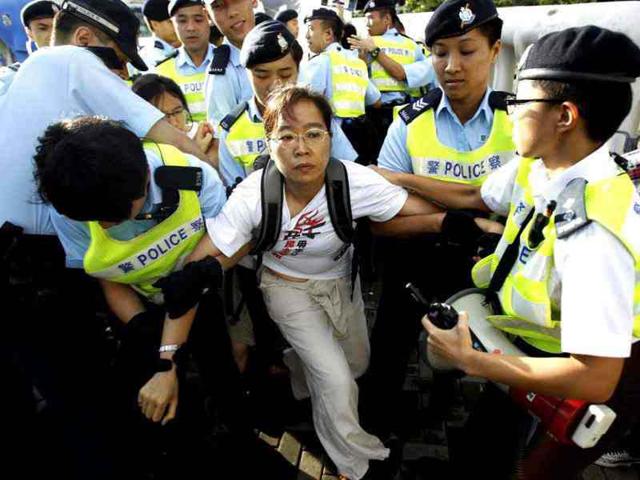 Pro-democracy protesters are removed by police outside the exhibition center where China's President Hu Jintao was presiding over a flag raising ceremony on the 15th anniversary of the Hong Kong handover to China in Hong Kong. (AP Photo/Wally Santana)