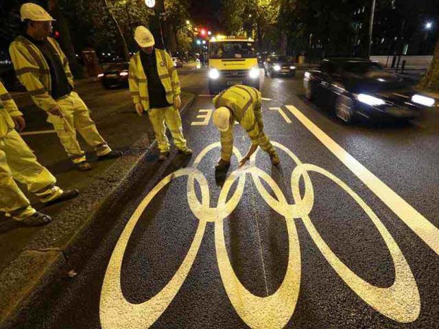 Workers mark out an Olympic Lane on the Embankment in London in preparation for the London 2012 Olympic Games. (AP Photo)
