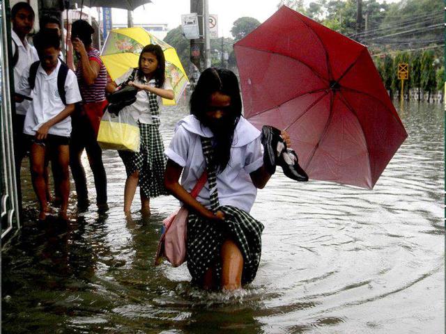 Students wade in knee-deep floodwater after a heavy downpour in Quezon City, Metro Manila. Heavy rain has flooded some roads, causing classes to be suspended in parts of Metro Manila, local media reported. Reuters photo/Cheryl Ravelo