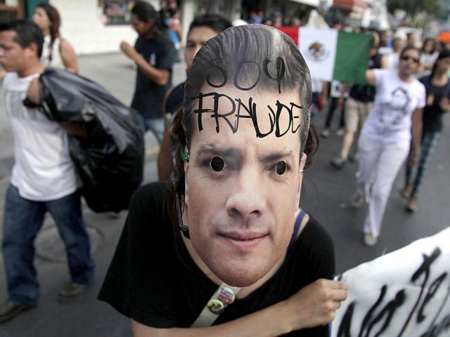 A member of the 'Yosoy132' (I am 132) movement wearing a mask of Mexico's presidential candidate Enrique Pena Nieto takes part in a demonstration demanding transparency in election results, marching through downtown streets in Monterrey. REUTERS/Daniel Becerril
