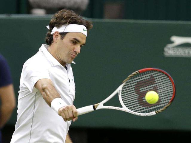 Roger Federer of Switzerland plays a shot to Novak Djokovic of Serbia during a men's semifinals match at the All England Lawn Tennis Championships at Wimbledon, England. (AP Photo/Kirsty Wigglesworth)