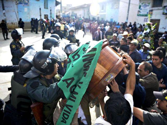 Peruvian police block the way to people carrying the coffins of three of the demonstrators who died during the protests against the Conga mining project in Celendin, Cajamarca, Peru. (AFP Photo/Ernesto Benavides)