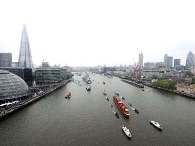 The Royal barge "Spirit of Chartwell" (C) carrying Britain's Queen Elizabeth II sails past "The Shard" during the Thames Diamond Jubilee Pageant in London. AFP Photo / Owen Humphreys