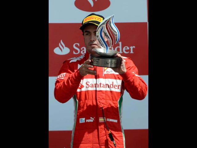 Ferrari's Spanish driver Fernando Alonso celebrates on the podium at the Silverstone circuit during the British Formula One Grand Prix. AFP/Dimitar Dilkoff