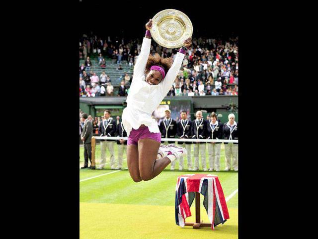 US player Serena Williams celebrates with the trophy, the Venus Rosewater Dish after her women's singles final victory over Poland's Agnieszka Radwanska on day 12 of the 2012 Wimbledon Championships tennis tournament at the All England Tennis Club in Wimbledon, southwest London. (AFP photo/Glyn Kirk)