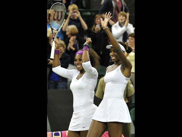 US players Venus Williams (R) and Serena Williams (L) celebrate after they won their women's doubles final match against Czech Republic's Andrea Hlavackova and Czech Republic's Lucie Hradecka on day 12 of the 2012 Wimbledon Championships tennis tournament at the All England Tennis Club in Wimbledon, southwest London. (AFP photo/Leon Neal)