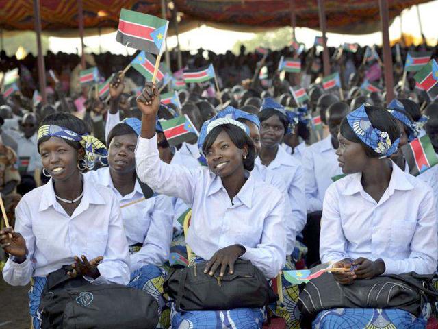 Women wave South Sudanese flags as they attend the country's anniversary celebrations, at the John Garang mausoleum in Juba. AP Photo/Shannon Jensen