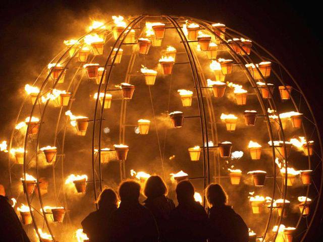 Women look at a metal structure filled with fire pots as World Heritage site Stonehenge is illuminated during an elemental Fire Garden display, which is part of the London 2012 Festival, in Salisbury, southern England. Reuters/Kieran Doherty
