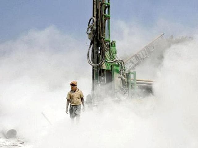 A worker walks out of dust emnating from a borewell rig drilling into the earth on the outskirts of Bangalore. India's six biggest cities - Mumbai, Delhi, Kolkata, Bangalore, Chennai and Hyderabad - are among those most affected by water shortages. According to UN, population growth and unsustainable consumption are driving Earth towards "unprecedented" environmental destruction. AFP/Manjunath Kiran