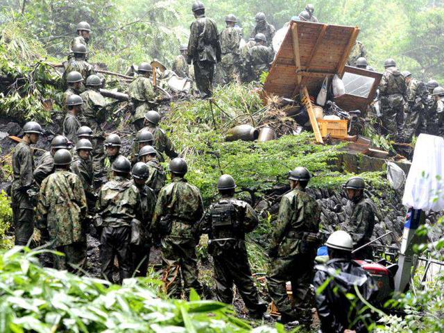 Japan's Self Defense Force members gather to search for missing residents in the rain, in Aso city, Kumamoto Prefecture, Japan. AP Photo