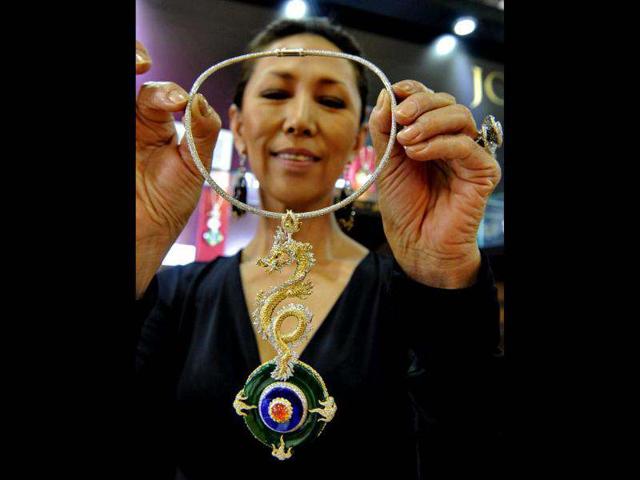 Korean designer Joon Courtenay displays her dragon pendant creation at the Singapore International Jewellery show in Singapore. AFP/Roslan Rahman