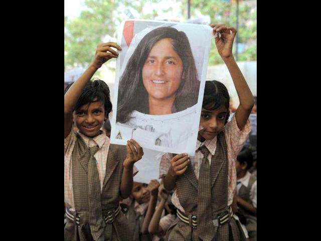 Shoolchildren pose with portraits of US astronaut of Indian-Slovenian origin Sunita Williams, during a prayer gathering on the eve of her second scheduled journey to space, in Ahmedabad. (AFP photo/Sam Panthaky)