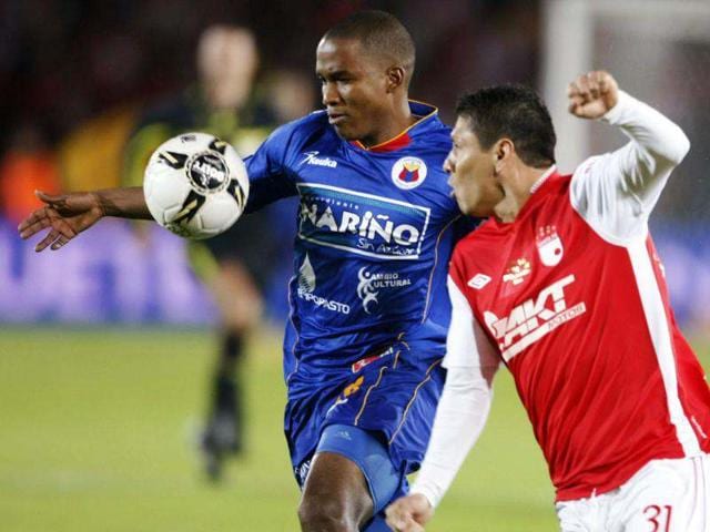 Deportivo Pasto's Juan Carlos Mosquera fights for the ball with Independiente Santa Fe's Diego Cabrera, during the final match of the Liga Postobon local soccer league tournament in Bogota, Colombia. AP/William Fernando Martinez