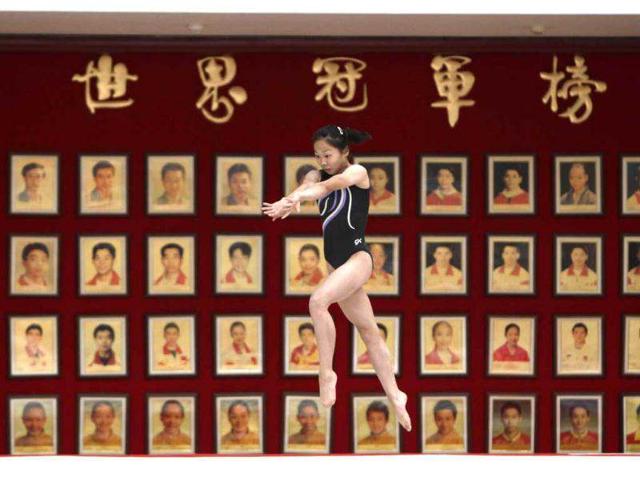 A gymnast from the Chinese national gymnastics team practices in front of portraits of Chinese Olympic and World Gymnastics champions during a training session at General Administration of Sport of China, in Beijing. These young gymnasts are training for the Rio de Janeiro 2016 Olympic Games. REUTERS/Jason Lee