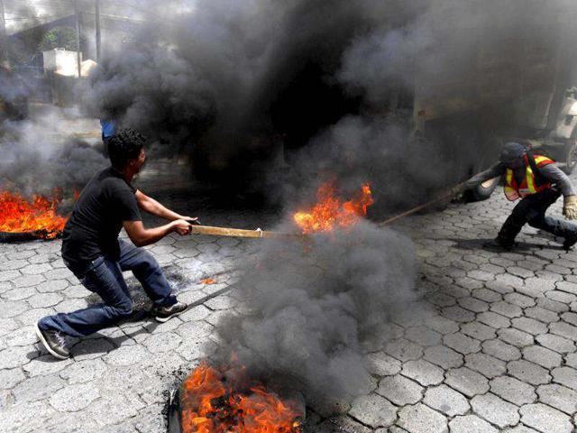 Members of Broad Opposition Front, FAO, civil organization, set on fire a vehicle belonging to Managua's town council during a protest in front of the Supreme Electoral Council, CSE, in Managua, Nicaragua. (AP Photo/Esteban Felix)