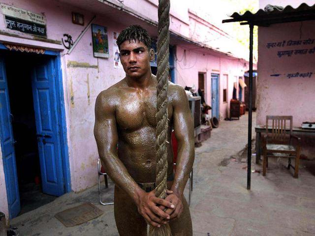 A wrestler pauses after a training session at the Guru Hanuman Akhara or a wrestling school, in New Delhi. India has hundreds of local academies for mud wrestling, which is an age old and a very popular sports of Indian villages. AP Photo/Manish Swarup