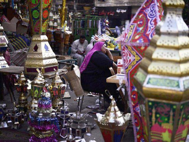 An Egyptian woman rests among handcrafted lanterns used traditionally during the holy Muslim fasting month of Ramadan in Cairo, on the eve of the first day of Ramadan. (AFP Photo/Gianluigi Guercia)