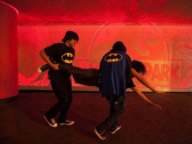 Teenagers wearing Batman capes role play while waiting for the opening for "The Dark Knight Rises," the third in Christopher Nolan's Batman trilogy at Universal CityWalk in Los Angeles. (AP Photo/Damian Dovarganes)