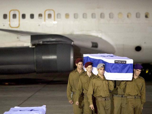 Israeli soldiers carry a coffin of victimes killed in bombing in Bulgaria after the remains arrived at Tel Aviv airport, Israel. AP/Dan Balilty