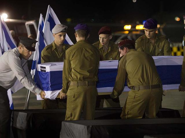 Israeli soldiers carry a coffin of victims who were killed in bombing in Bulgaria upon the remains arrival at Tel Aviv airport, Israel. AP/Dan Balilty