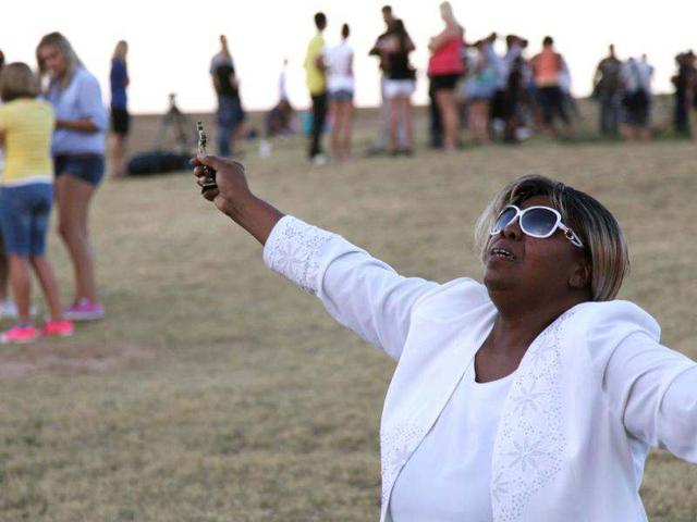 Marietta Perkins falls to her knees in sorrow and prayer at a vigil across the street form the movie theate in Aurora, Colorado. (AP Photo/Robert Ray)
