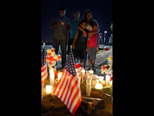 People pray at a makeshift memorial during a vigil for victims of the Century 16 movie theatre where a gunmen attacked movie goers during an early morning screening of the new Batman movie "The Dark Knight Rises" in Aurora, outside of Denver, Colorado. (Kevork Djansezian/Getty Images/AFP)